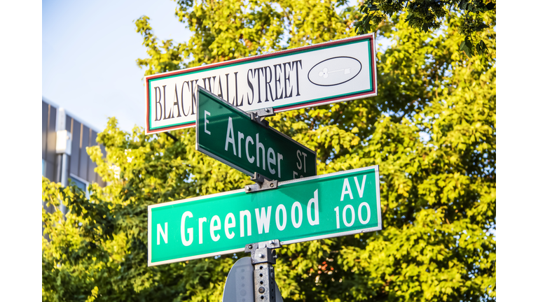 Black Wall Street and N Greenwood Avenue  and Archer street signs in Tulsa, Oklahoma.