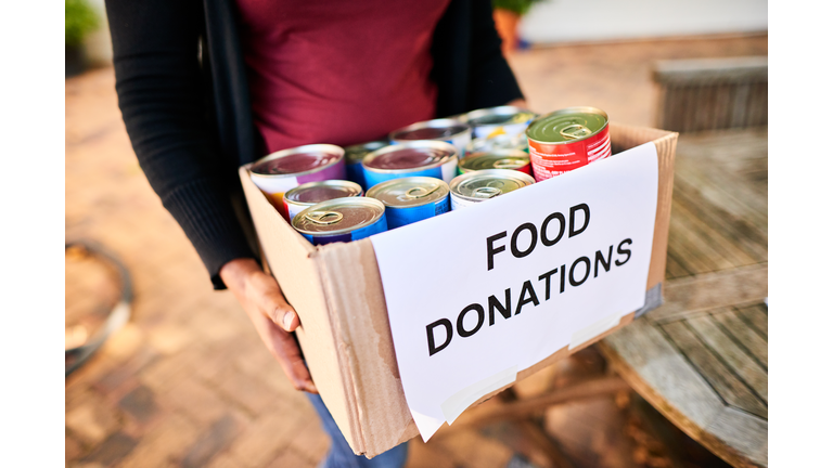 Close-up of a young woman carrying a box of food donations