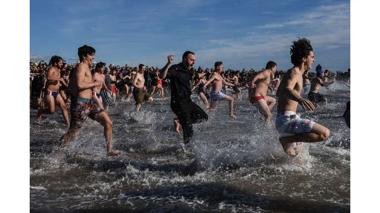 Scores Of Swimmers Take Icy Plunge