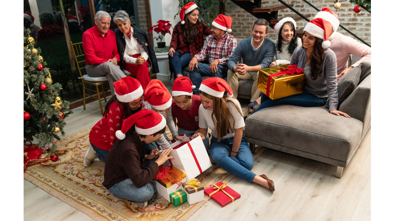 Happy kids opening their gifts on Christmas Eve