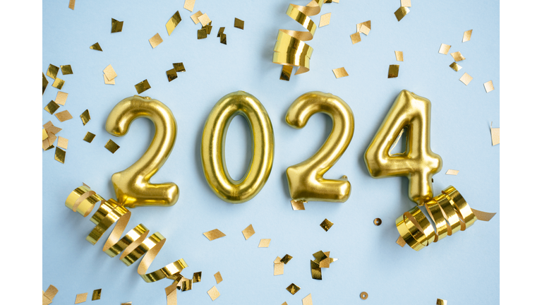 2024 New Year number. Golden digits and confetti over blue background.