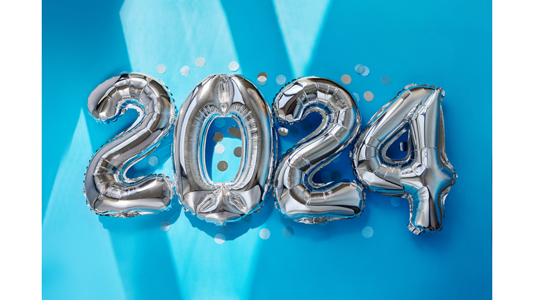 Silver numbers 2024 new year balloons in sunlight blue background