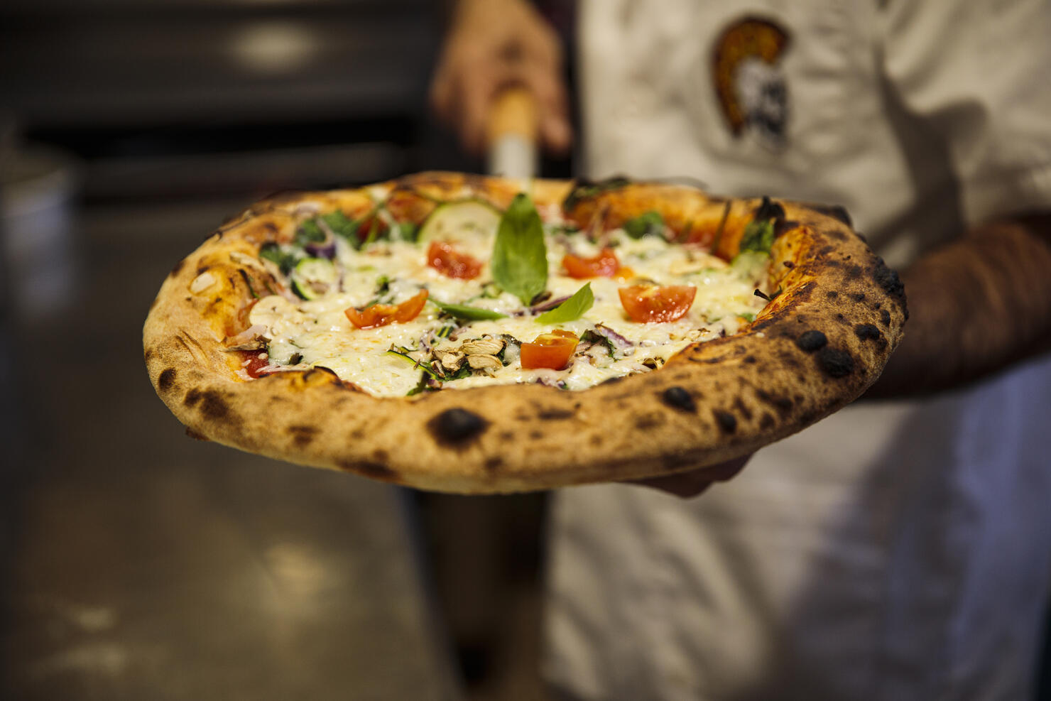 Pizza chef with freshly baked pizza