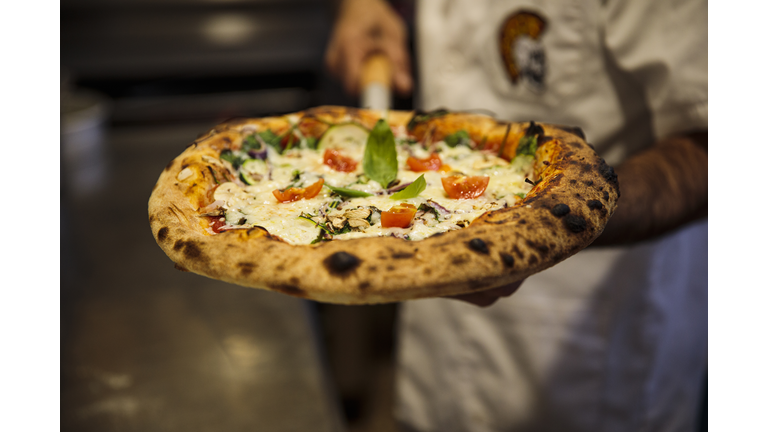 Pizza chef with freshly baked pizza