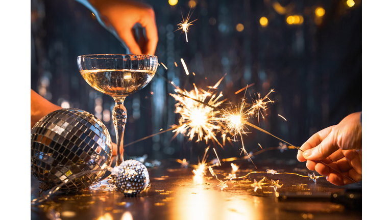 New Year celebration concept with golden sparklers and champagne flutes
