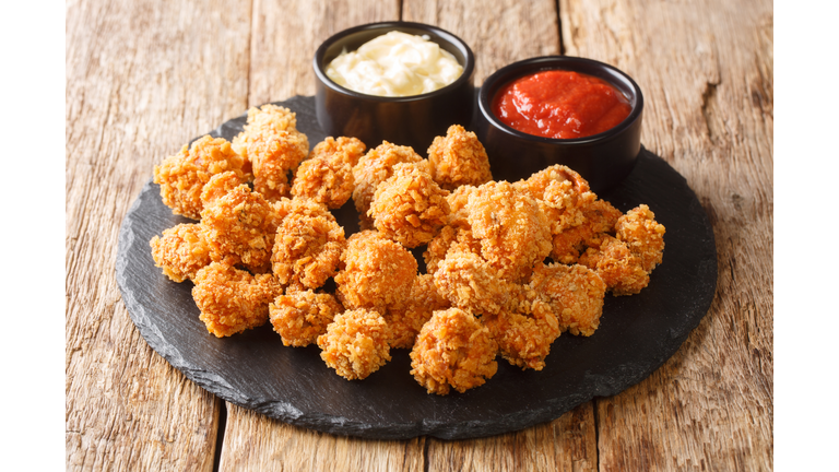 Chicken Popcorn are small slices of chicken that were coated breading and deep fried closeup on the table. Horizontal