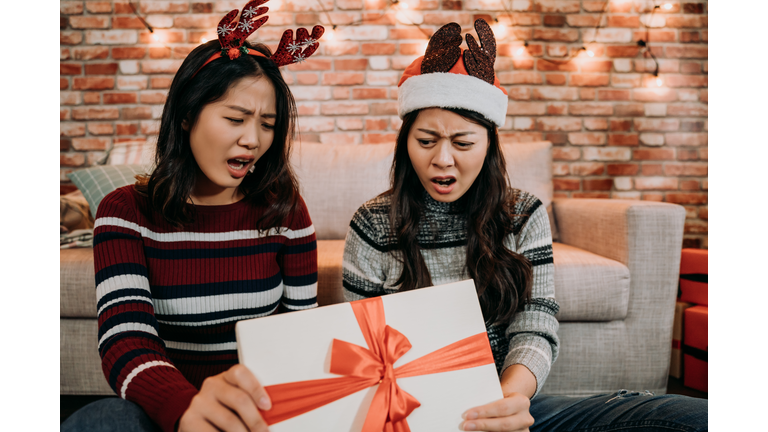 girls open gift box at home feeling displeased