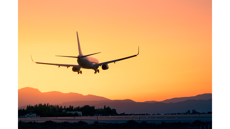 Epic landing with the sunset and the mountains, plane landing beneath a breathtaking sunset, sunset landing