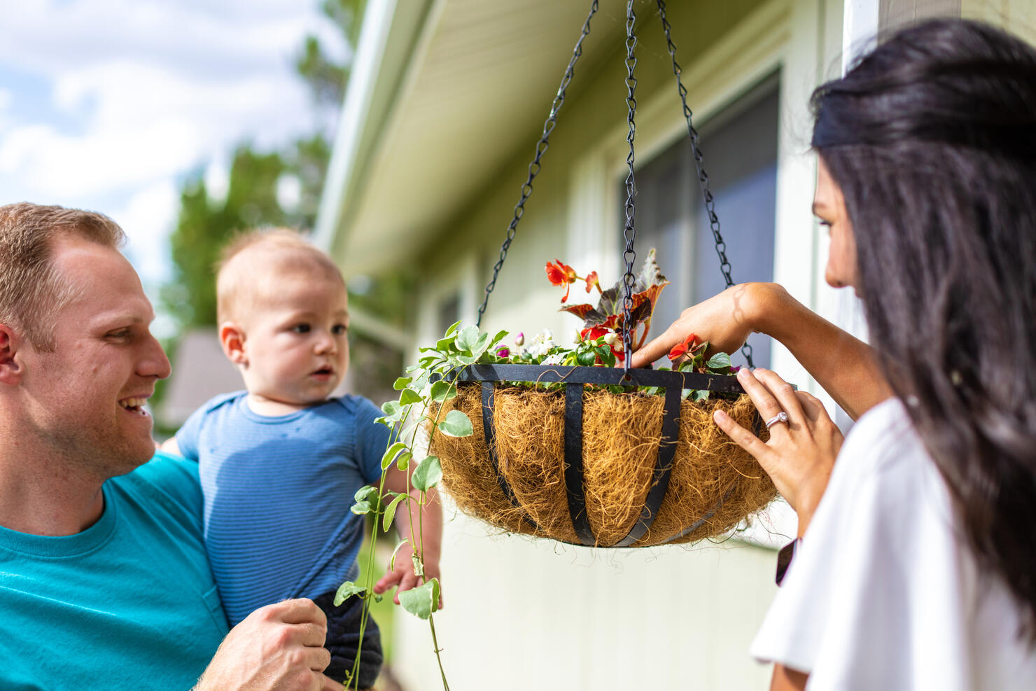 Young Family including Millennial Generation Father and Mother with Pre Toddler Infant Playing in Yard of their Home on a Sunny Summer Day