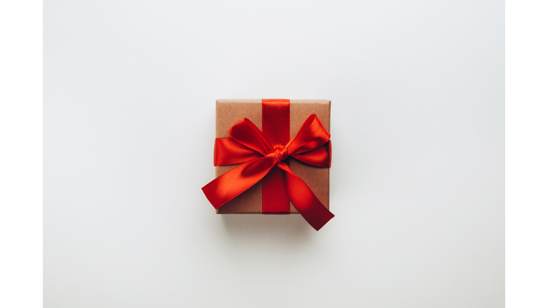 Small gift with red bow on light background