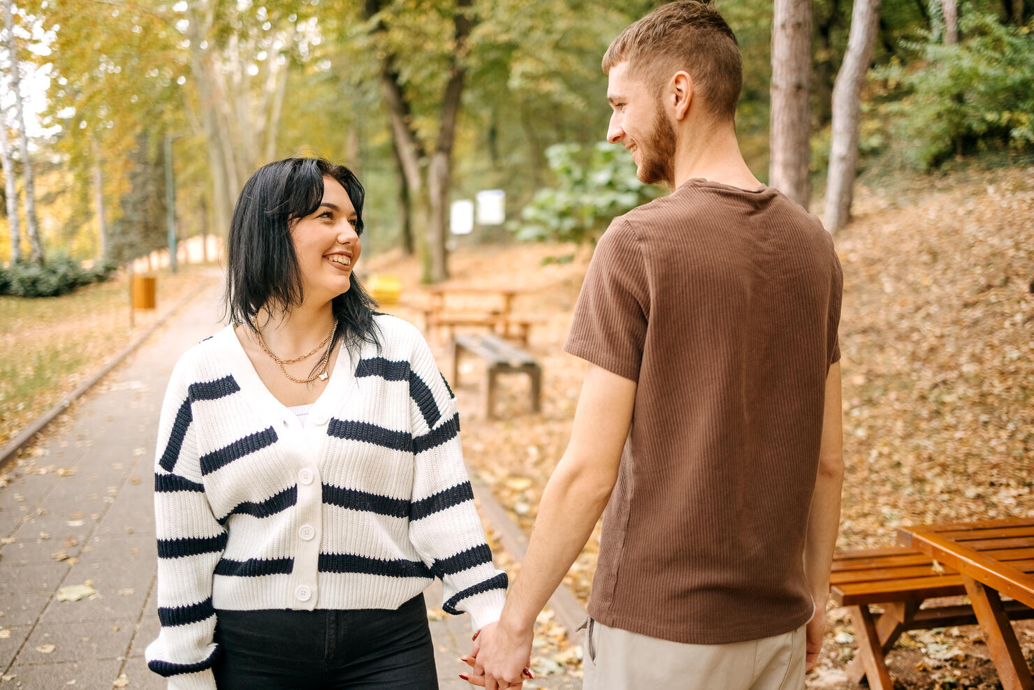 Millennial generation couple spending time outside in Autumn holding hands