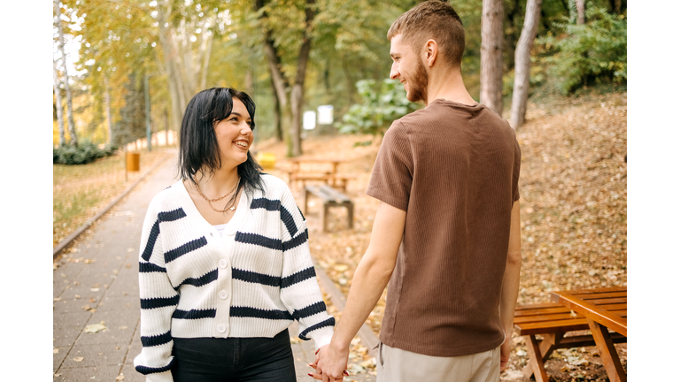 Millennial generation couple spending time outside in Autumn holding hands