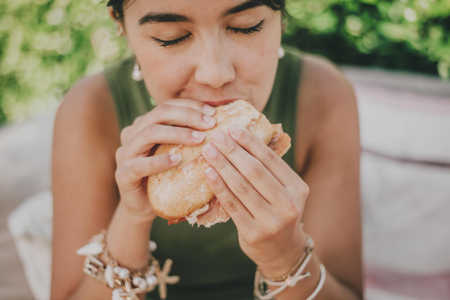 young woman enjoys a serrano ham  sandwich outdoors