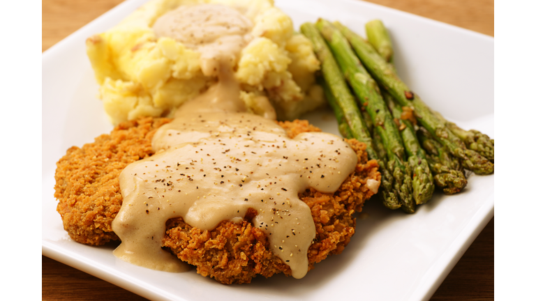 A plate of fried chicken, mashed potatoes and asparagus 