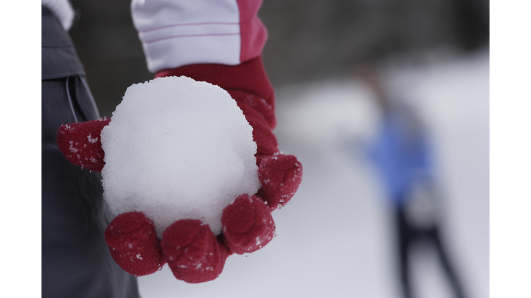 Woman holding a snowball, mid section, close-up