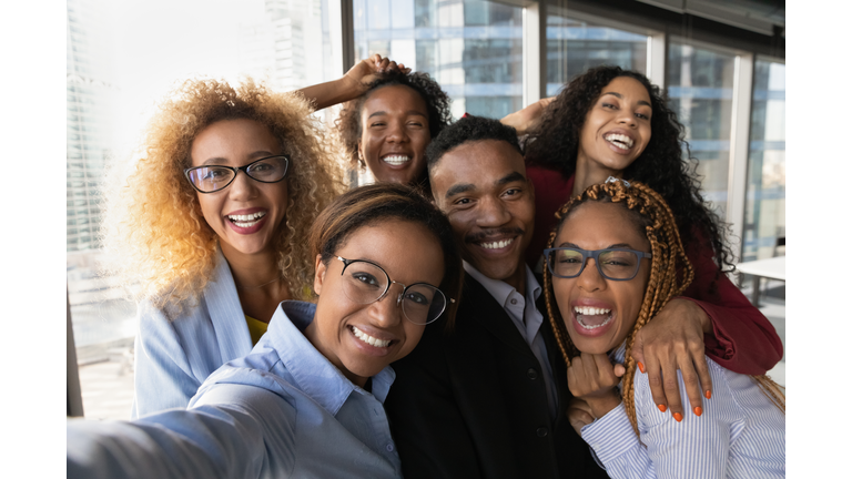 Portrait of smiling diverse colleagues pose for selfie