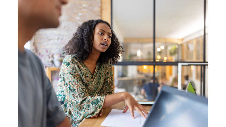 Young entrepreneur talking with colleagues in office boardroom