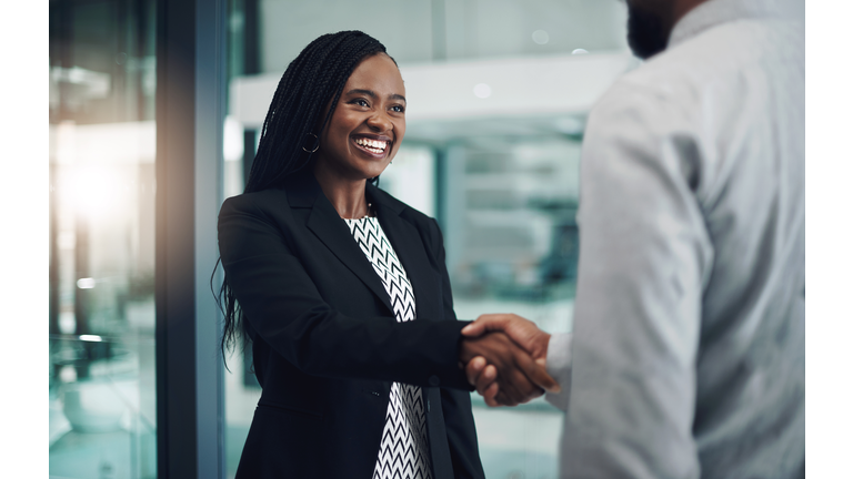 Shot of a young businesswoman shaking hands with a colleague in a modern office