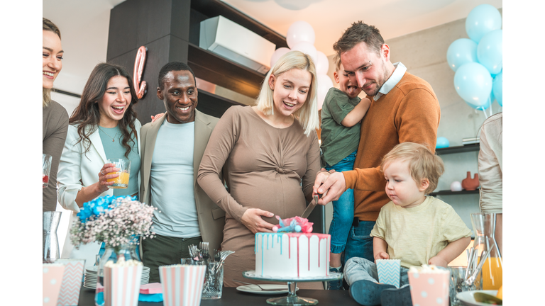 A mixed-race group of friends gathers for a joyous gender reveal party