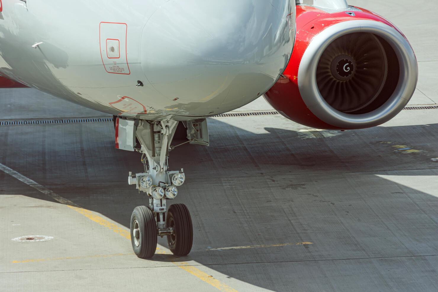 The nose gear, nose, and engine of the aircraft. Parking view.