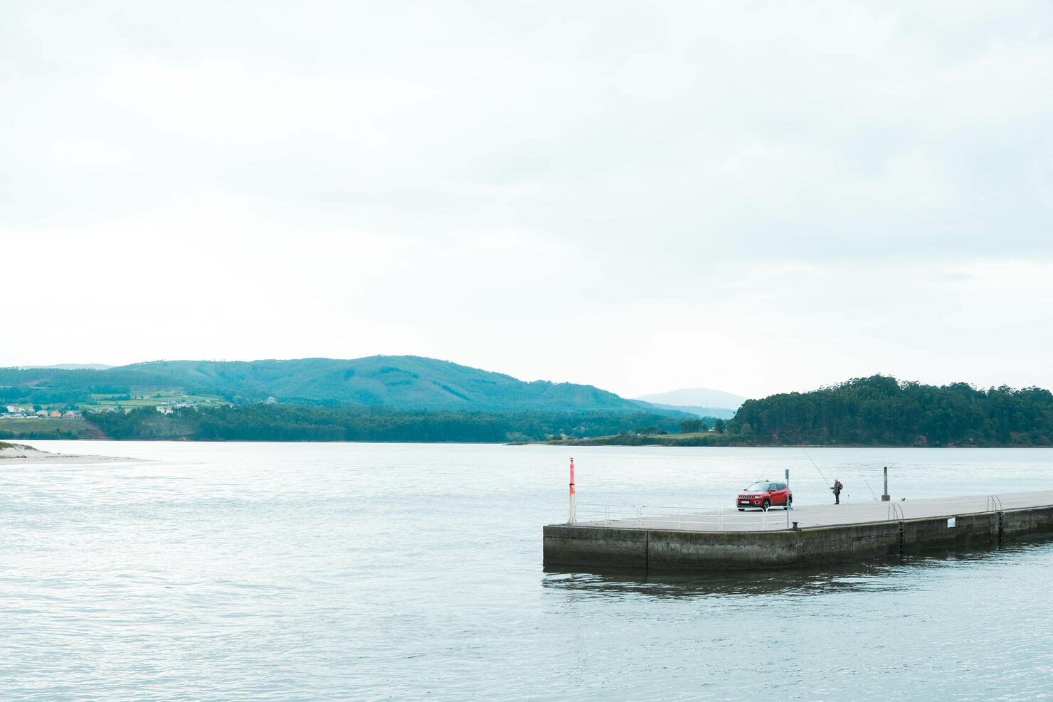 Man fishing on the dam of an estuary