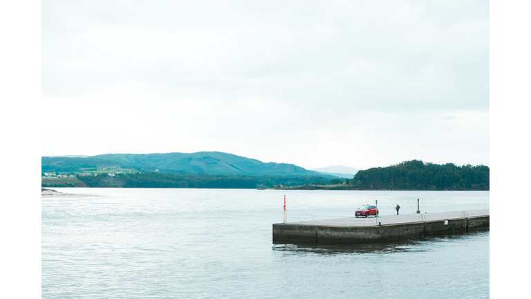 Man fishing on the dam of an estuary