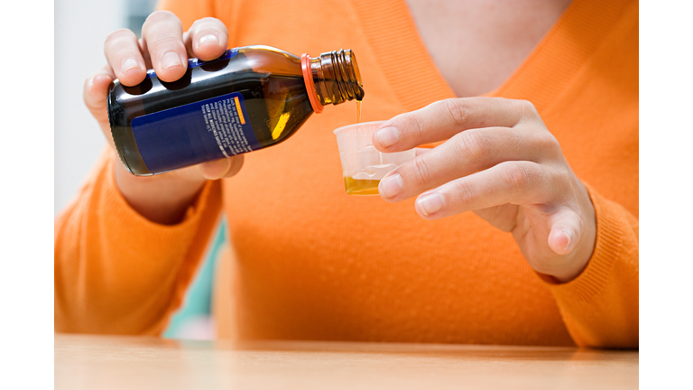 Woman pouring cough medicine