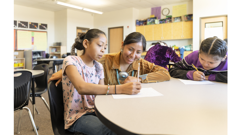 Indigenous navajo teacher helping students with their work