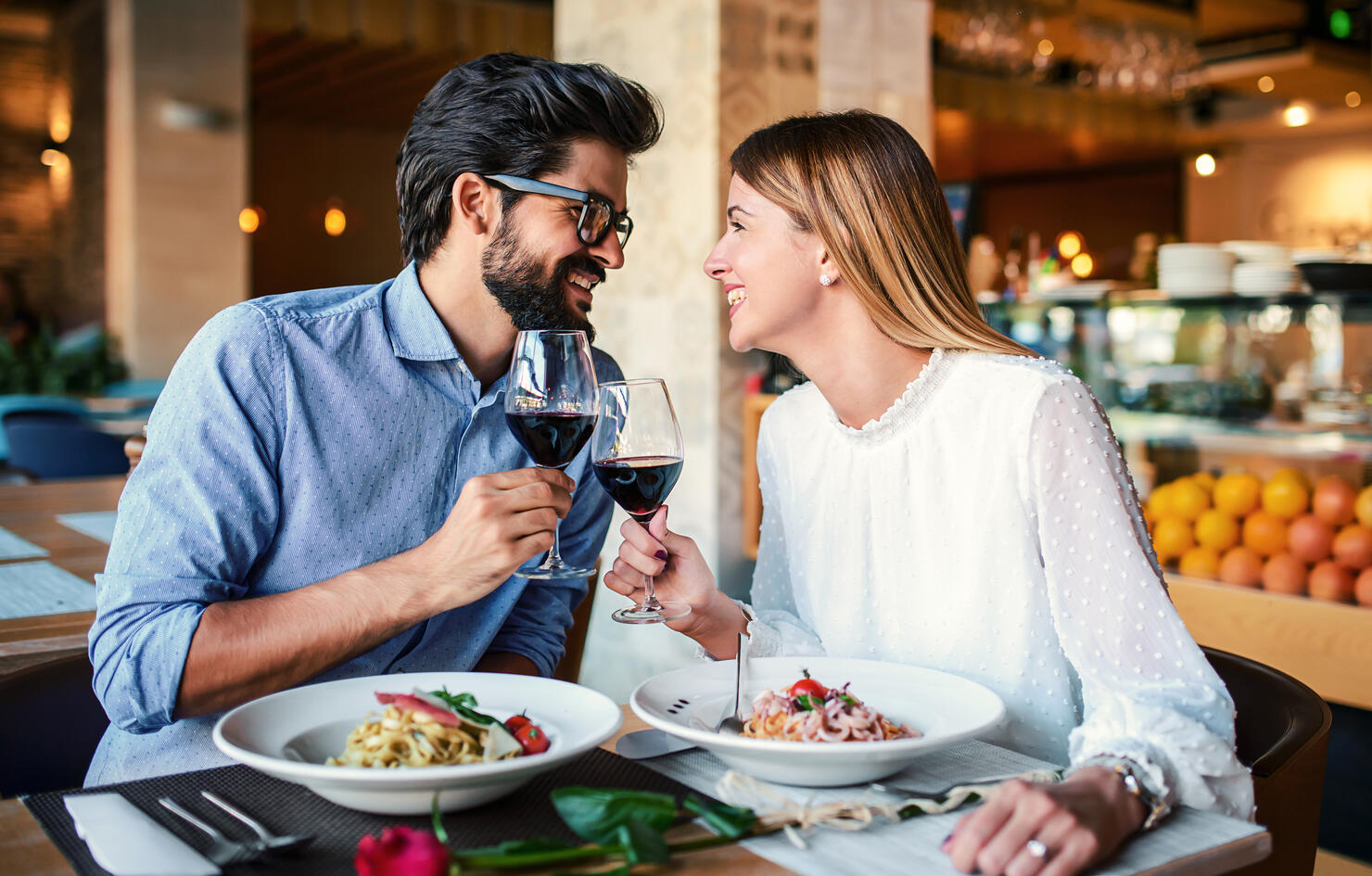Paste and red wine. Young couple enjoying lunch in the restaurant. Lifestyle, love, relationships, food concept