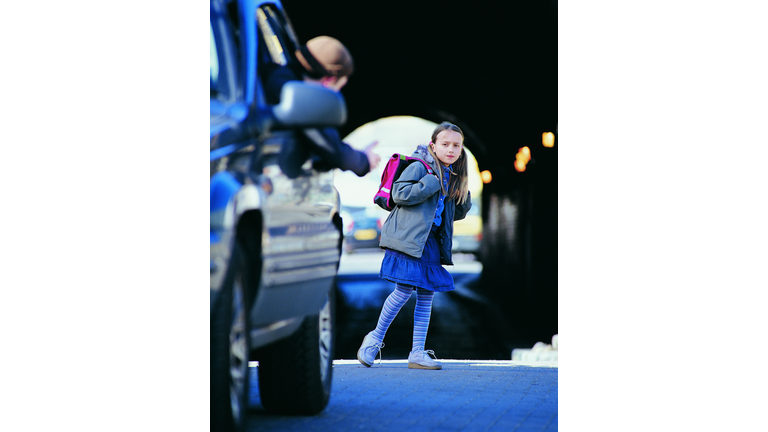Man in a Car Beckoning an Apprehensive Girl Standing in a City Street