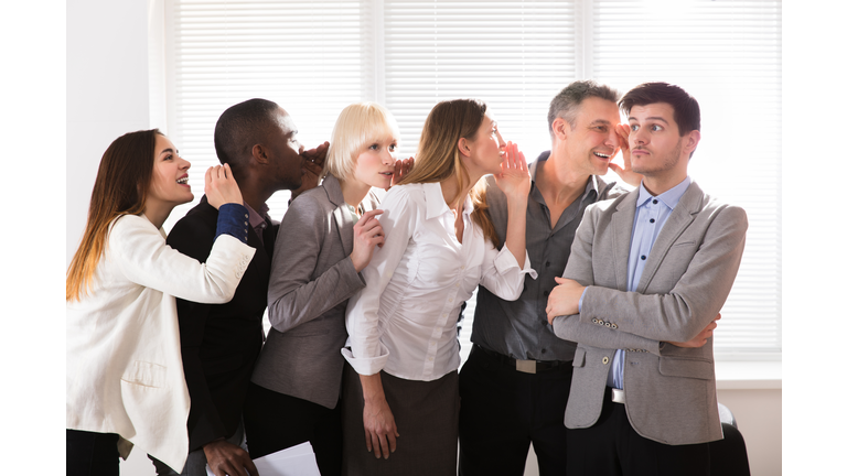 Secretive Business Colleagues Whispering In The Office