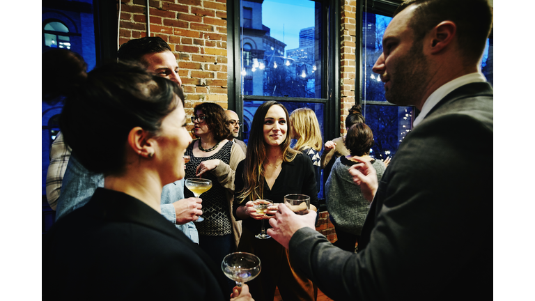 Laughing friends having drinks during dinner party