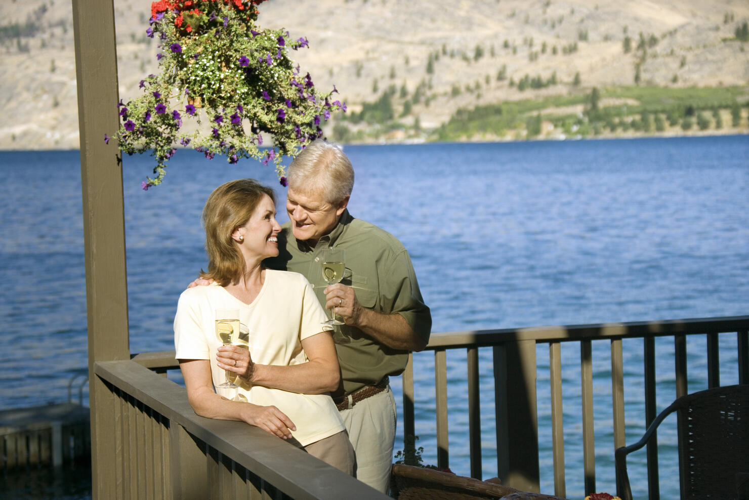 Couple standing on patio with wine glasses