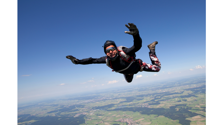 Man skydiving over rural landscape