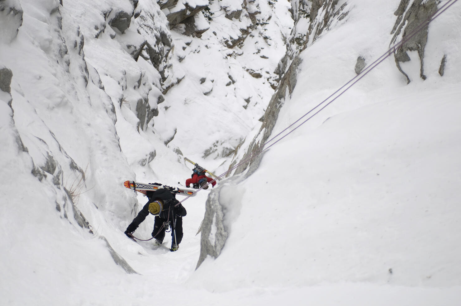 Backcountry skiers climbing down into the Y-Not Couloir in the Wasatch Mountains