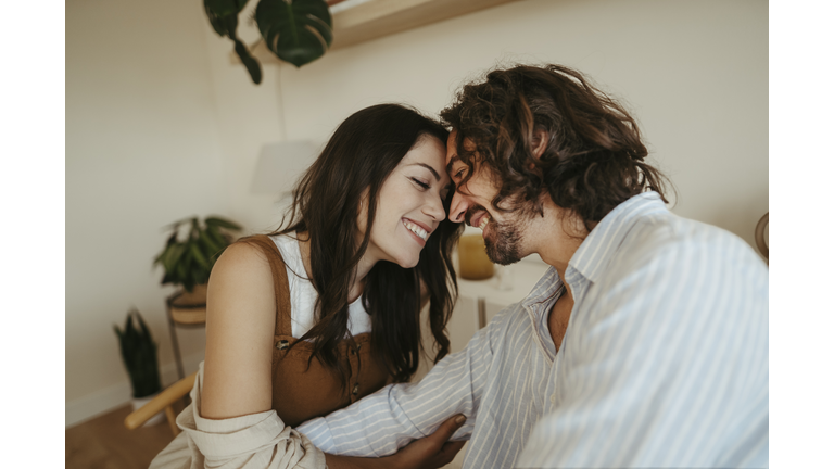 Happy couple touching foreheads at home