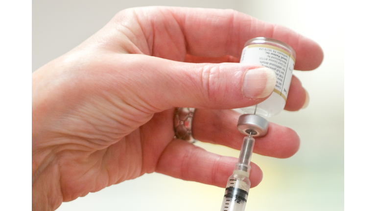 A heatlh worker prepares an injection du