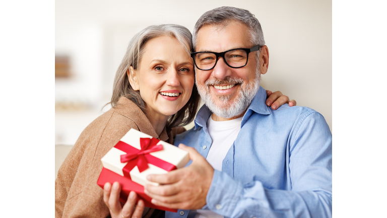 Happy romantic senior couple in love congratulating each other with Valentine's Day at home