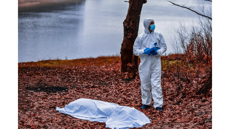 Forensic scientist on a crime scene collecting evidence