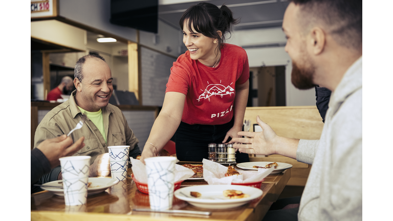 Waitress clearing plates from table at restuarant