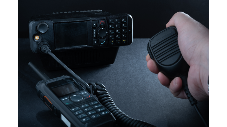 Closeup of pair of mobile two-way radios for Amateur radio operators against dark background.