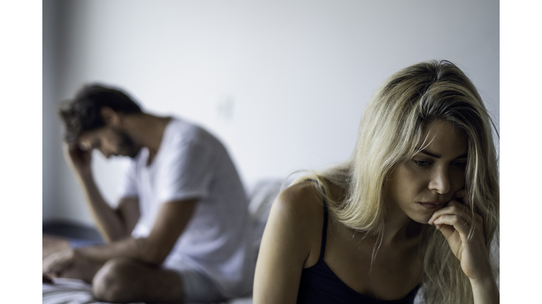 Upset couple sitting in bedroom