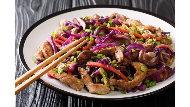 Chinese cuisine pork moo shu with vegetables and mushrooms close-up in a plate. horizontal