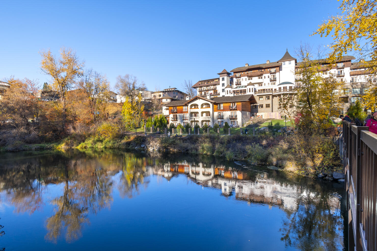 View of the Wenatchee River at autumn with fall colors on the leaves as it flows past the Bavarian themed town of Leavenworth past the public park at Blackbird Island at Leavenworth, Washington, USA.