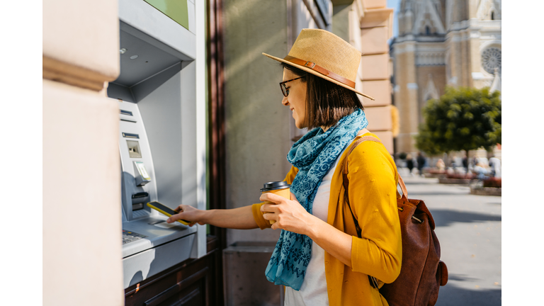 Young Woman Withdrawing Cash From The ATM