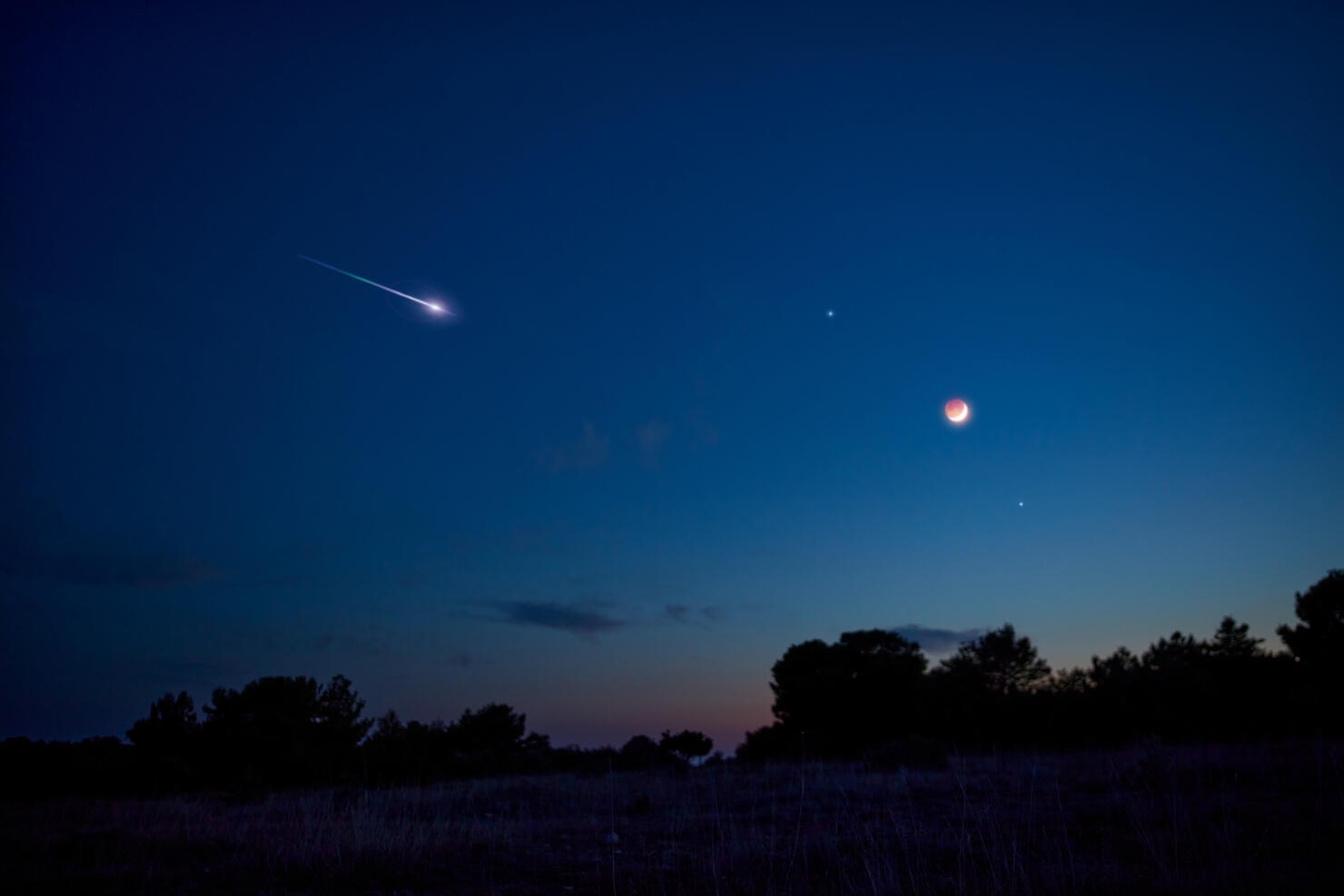 Landscape silhouette of a evening sky with crescent Moon eclipse, meteor, shooting star and planets.