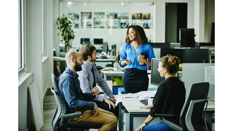 Businesswoman leading meeting with colleagues