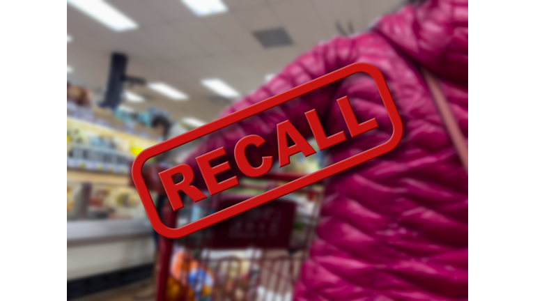 Blurry focus on a customer shopping inside a grocery store with the word Recall in the foreground