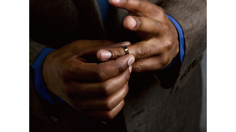 Business man putting on wedding band