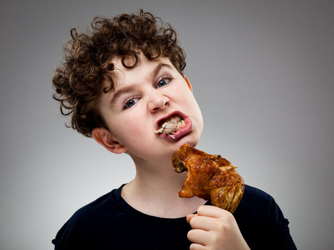 Boy eating chicken leg